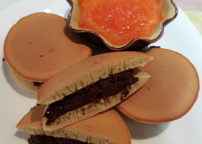 Dorayaki sur une assiette coupelle contenant une sauce orangée