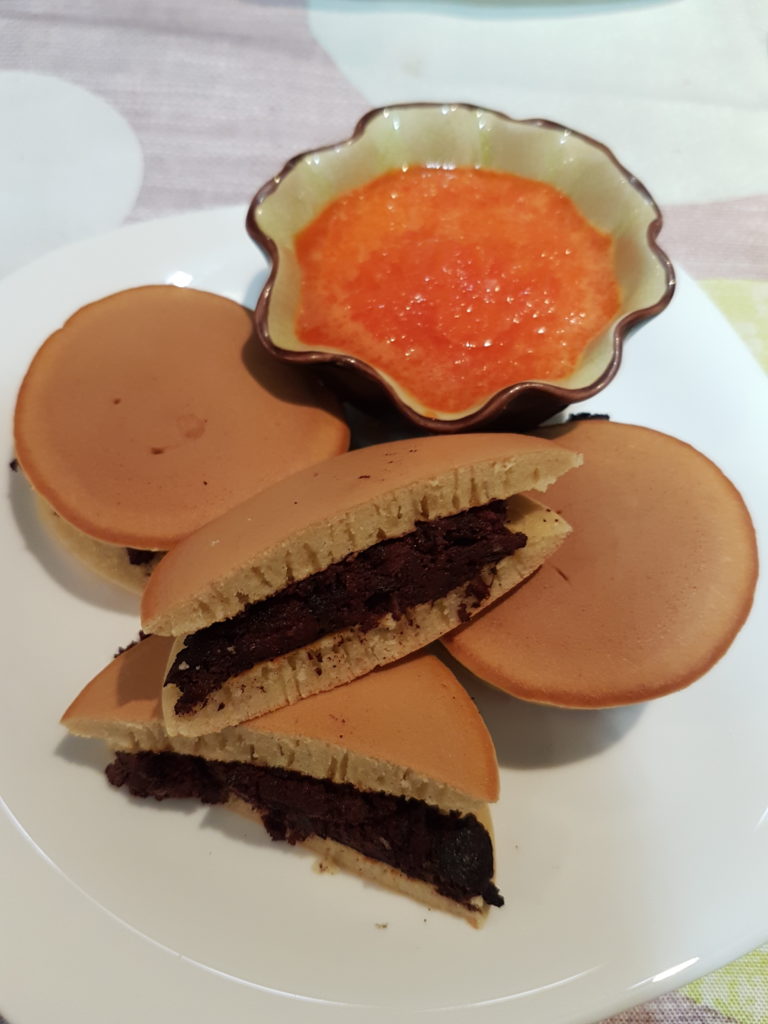 Dorayaki sur une assiette coupelle contenant une sauce orangée