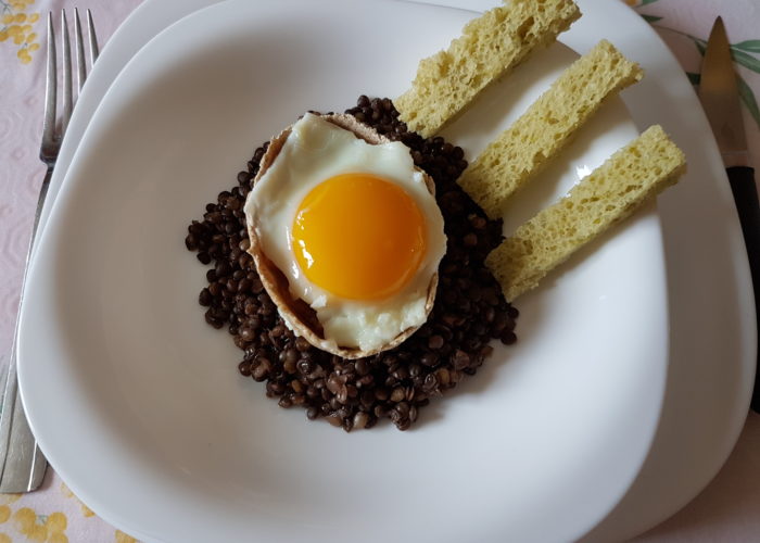 oeuf au plat dans une coque sur des lentilles et des mouillettes vertes sur le coté photo paysage