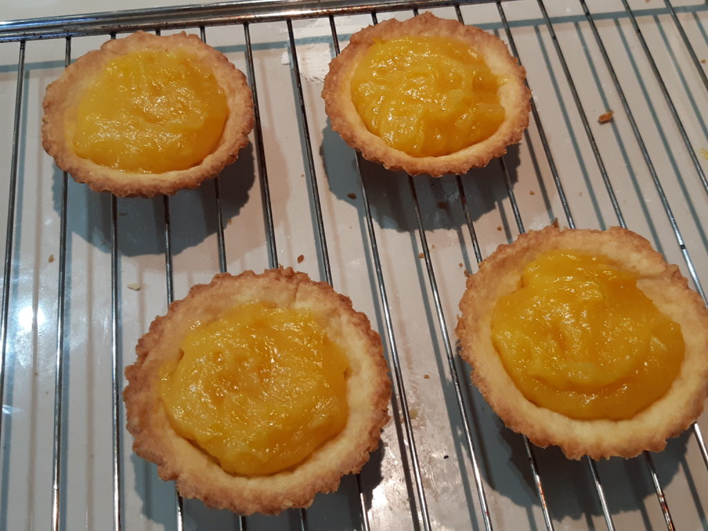 fonds de tartelette sur une grille garnis avec une crème jaune épaisse