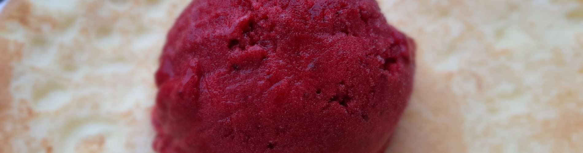 boule de sorbet rouge profond sur une crêpe