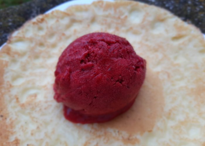 boule de sorbet rouge profond sur une crêpe