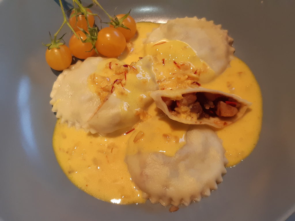 ravioles dans une assiette couvertes de sauce safranée