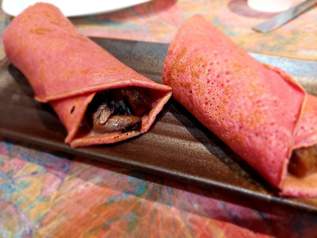 crêpe rose roulée avec des morceaux de viande