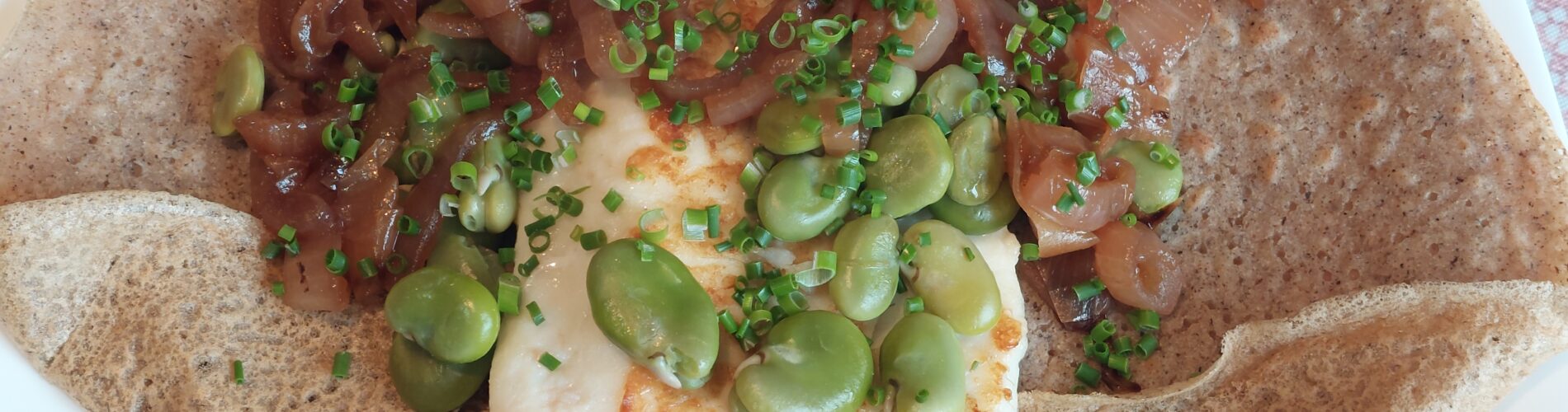 crepe garnie avec du poisson blanc de l'oignon et des feves