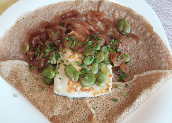 crepe garnie avec du poisson blanc de l'oignon et des feves