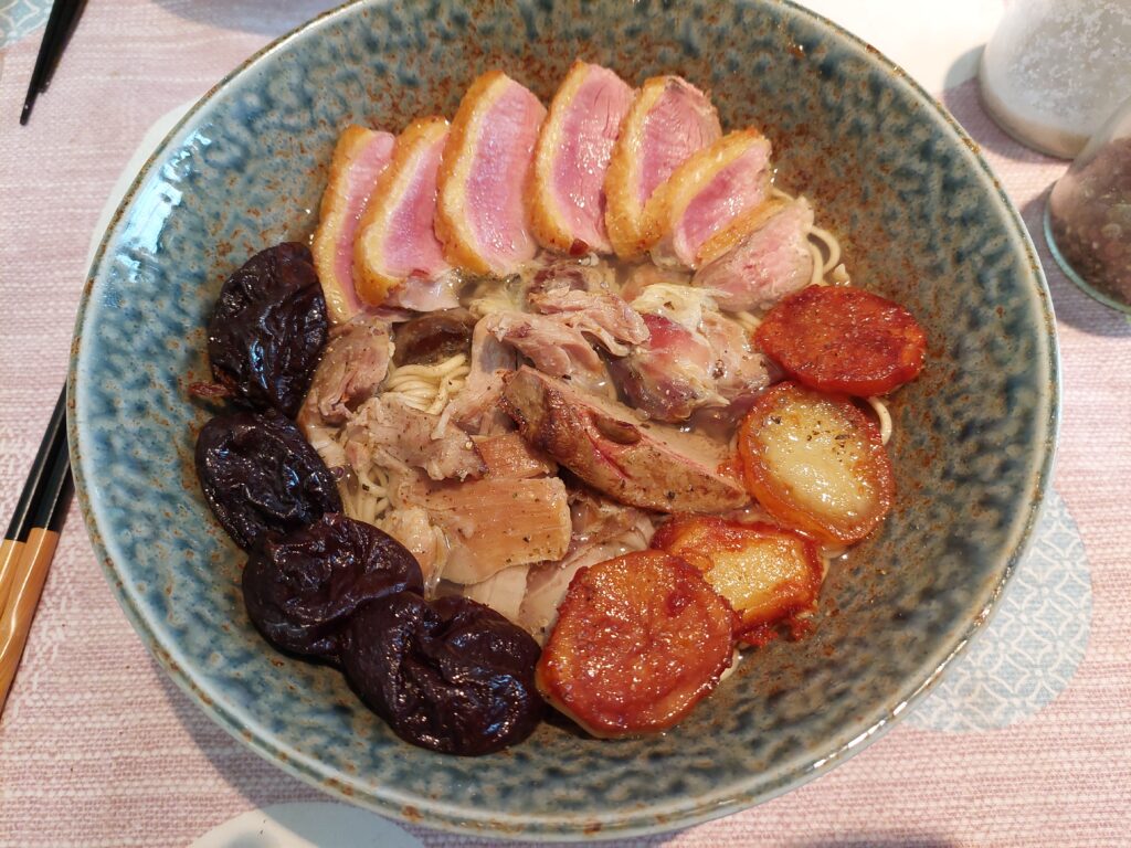 ramen dans un bol avec des la viande de canard et des pruneaux