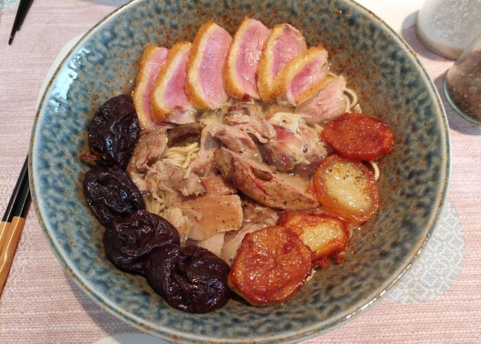 ramen dans un bol avec des la viande de canard et des pruneaux