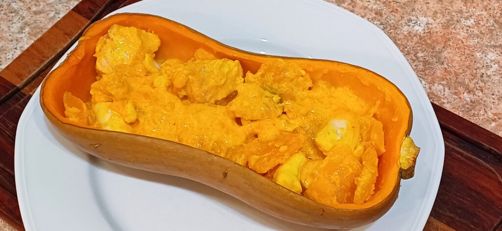 demi courge butternut évidée remplie avec des morceaux de légume et de poisson